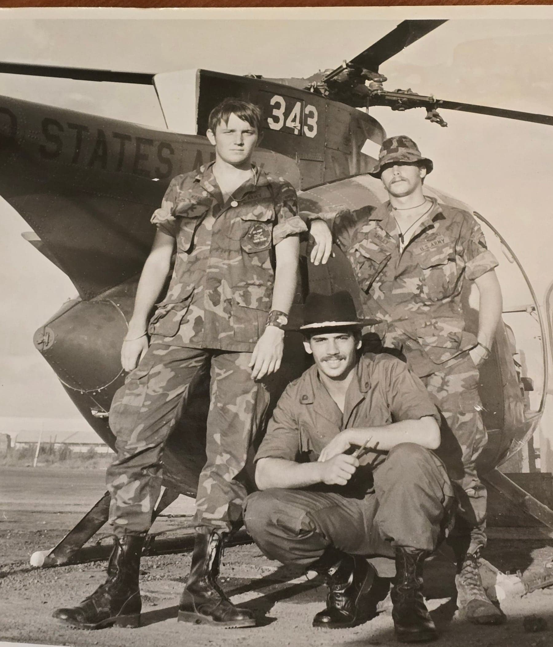 Soldiers of John Schembari's unit with a U.S. Army helicopter in Vietnam